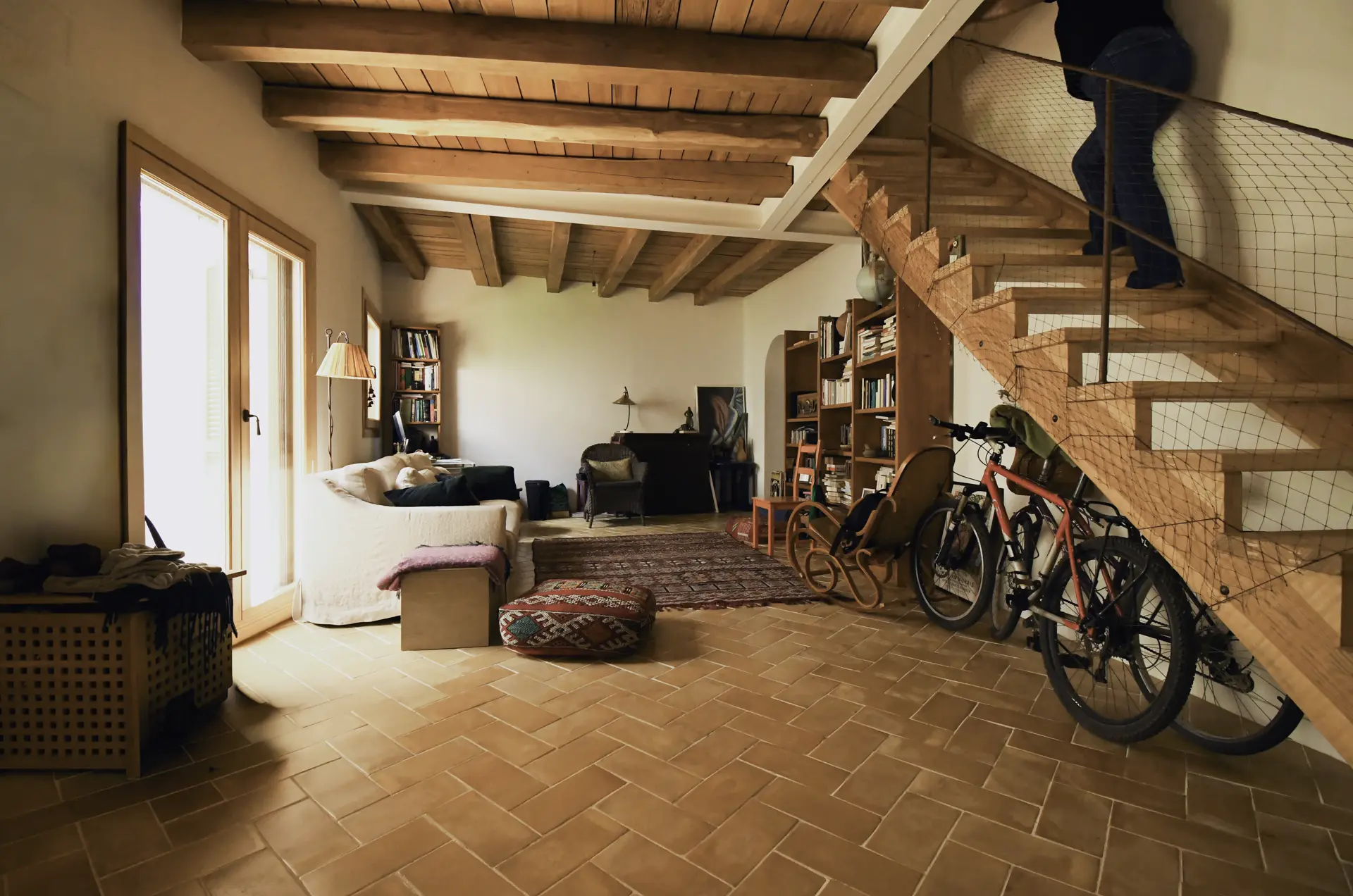 Salón con escalera y vigas de madera de la casa cueva de la Bola de Oro (Granada)